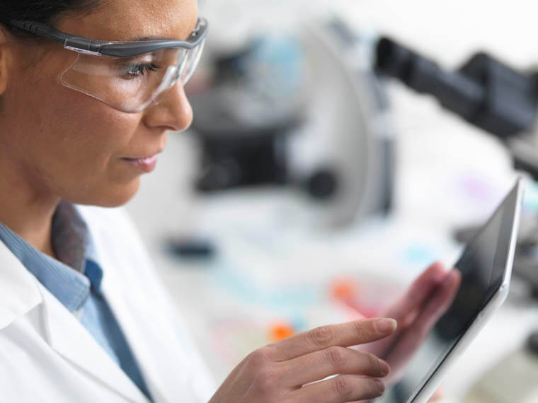 Scientist viewing test results on a digital tablet in lab
